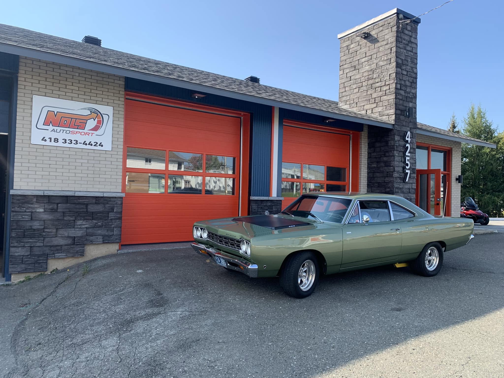 Chevrolet Camaro rouge devant le garage